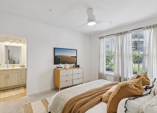A bedroom with a bed, dresser, and mirror.