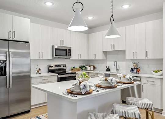 A modern kitchen with a large island and stainless steel appliances.