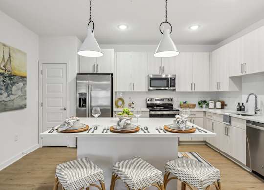 A kitchen with a white table and chairs.