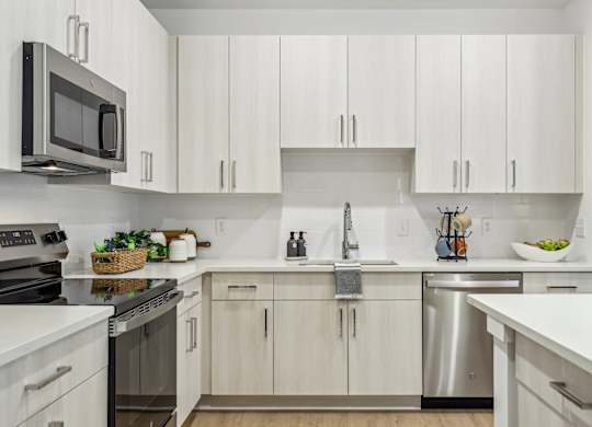 A kitchen with white cabinets and stainless steel appliances.