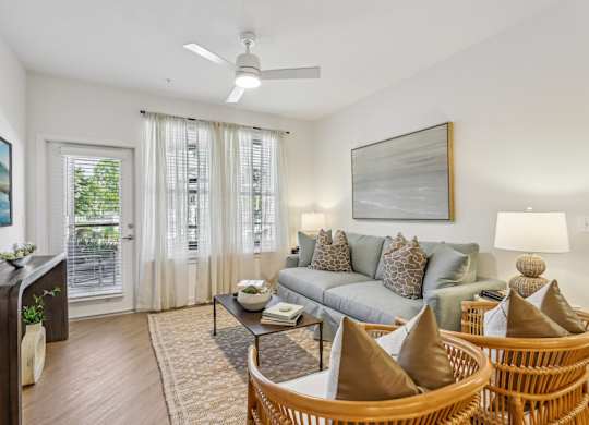 A living room with a grey couch, a wooden table, and a painting on the wall.