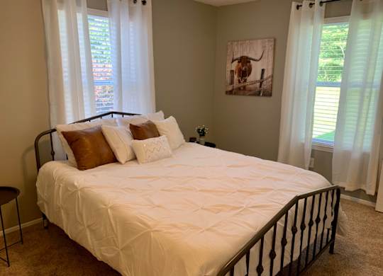 bedroom with two windows and plush carpet at The Avery at Auburn Apartments in Auburn, AL