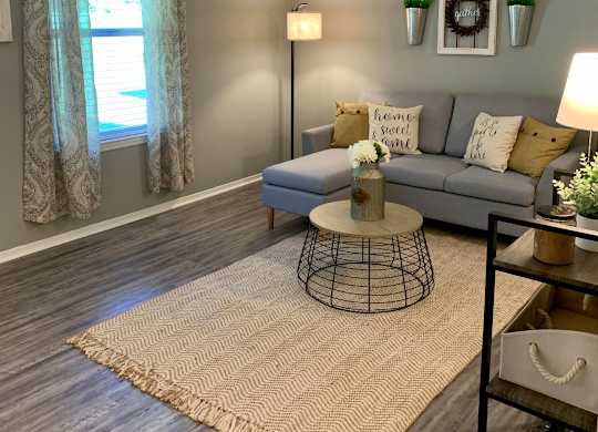 Living room with window and plank flooring at The Avery at Auburn Apartments in Auburn, AL