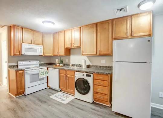 A kitchen with wooden cabinets and white appliances.