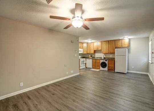 A kitchen with wooden cabinets and a ceiling fan.