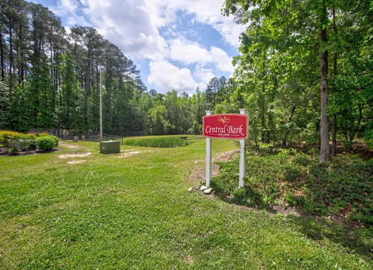 A sign that says Central Bark stands in a grassy area.