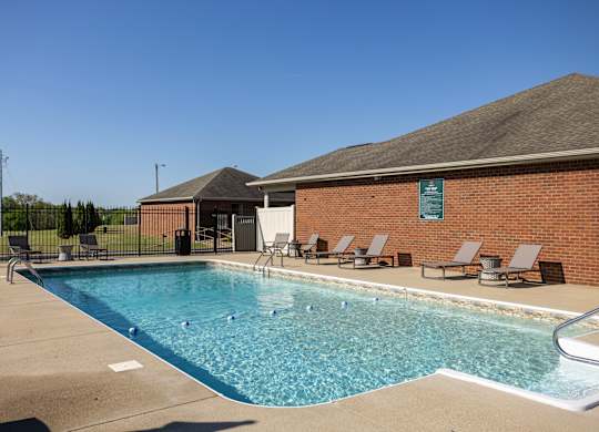 A pool with a building behind it.