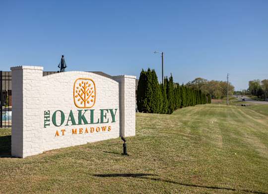 A sign that says "The Oakley at Meadows" stands in a grassy field.
