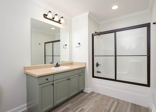 A bathroom with a sink, mirror, and cabinets.