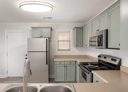 A kitchen with a stainless steel refrigerator and a stove top oven.