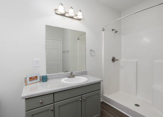 A bathroom with a sink, mirror, and bathtub.