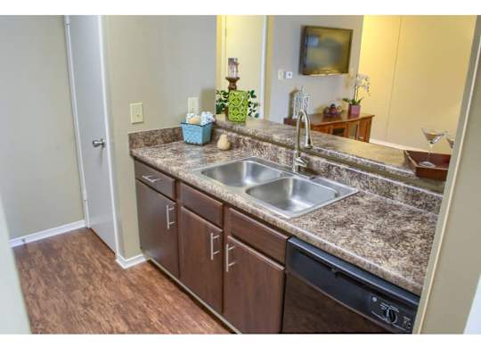 an open floor plan kitchen with designer plank flooring at at The Oakley at Hillcrest in Mobile, AL