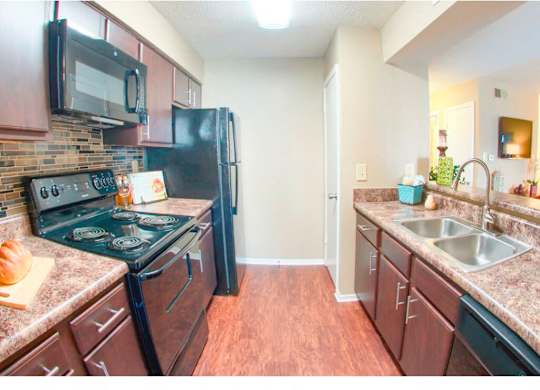 an open floor plan kitchen with designer plank flooring at The Oakley at Hillcrest in Mobile, AL