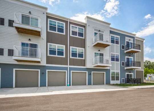 an apartment building with balconies and garages at The Promenade at Founders Square in Portage, IN