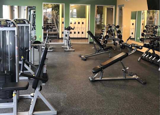 a gym with weights and other exercise equipment a game room with a pool table and chairs at The Pomenade at Founders Square Apartments in Portage, IN