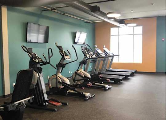 a gym with a row of exercise bikes at The Pomenade at Founders Square Apartments in Portage, IN