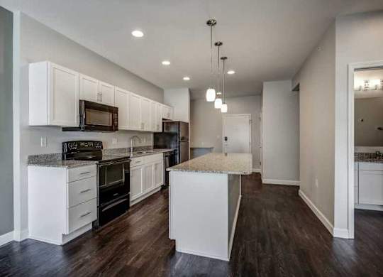 an empty kitchen with white cabinets and a counter top