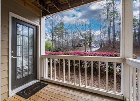 A wooden front patio with white railing at Summerchase at Riverchase in Hoover, Alabama.