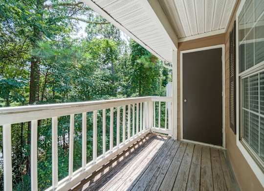 A wooden patio balcony surrounded by trees at Summerchase at Riverchase in Hoover, Alabama