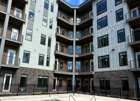 A sparkling swimming pool with wide, shallow entry steps in front of the Fitzroy Apartments in Birmingham, Alabama.