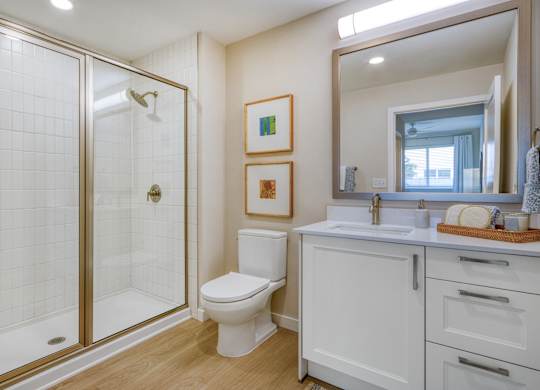 A bathroom with a toilet, sink, and shower.