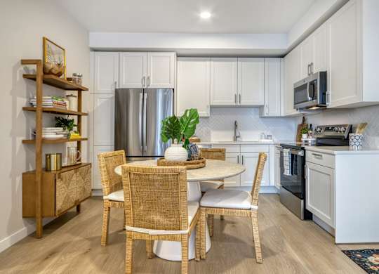 A kitchen with a table and chairs in the middle of it.