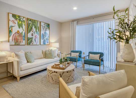 A living room with a white couch, a coffee table, and a painting on the wall.