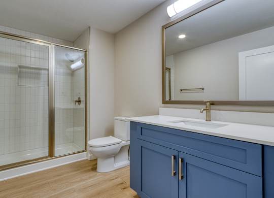 A bathroom with a toilet, sink, and shower.