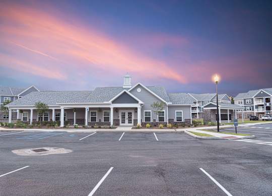 A parking lot in front of a building with a street light.