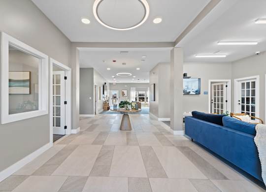 A long hallway with a blue couch on the right side.