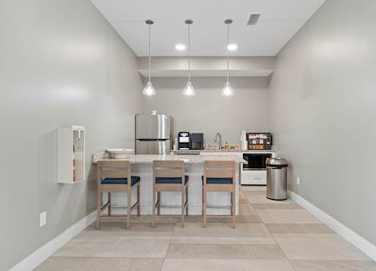 A kitchen with a table and chairs.