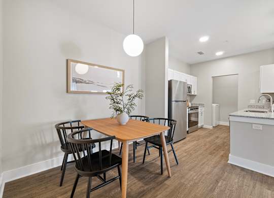 A modern kitchen with a dining table and chairs.