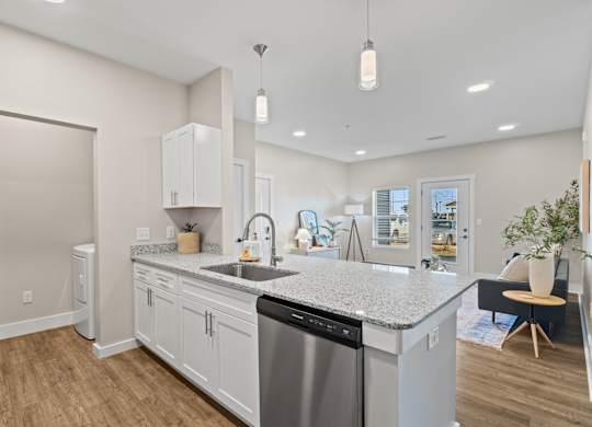 A modern kitchen with a stainless steel dishwasher and white cabinets.