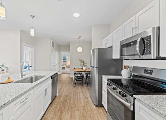 A modern kitchen with stainless steel appliances and white cabinets.
