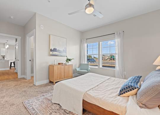 A bedroom with a bed, a dresser, and a painting on the wall.