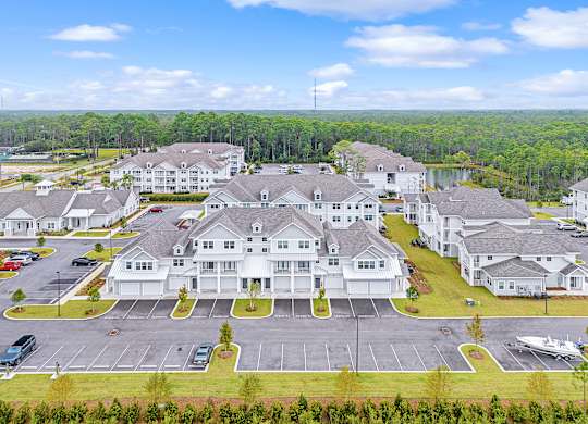 A large white building with a parking lot in front of it.