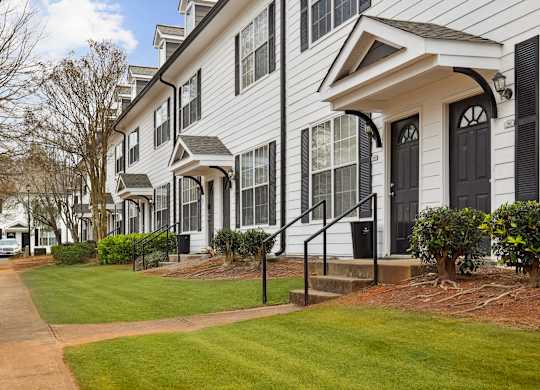 A white two story house with a black door and windows.