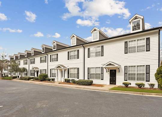 A row of townhouses with a clear blue sky above them.