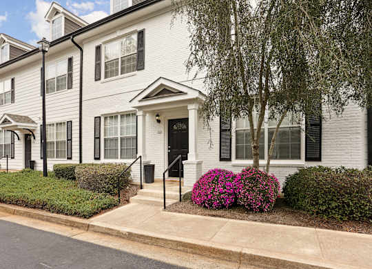 A white house with a black front door and windows.