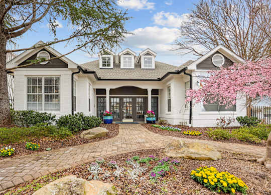 A white house with a grey roof and a grey front door.