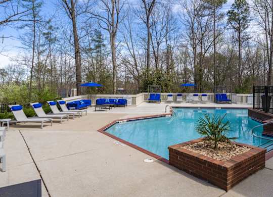 Outdoor pool and deck area with lounge chairs at Summerchase at Riverchase Apartment Homes in Hoover, Alabama.
