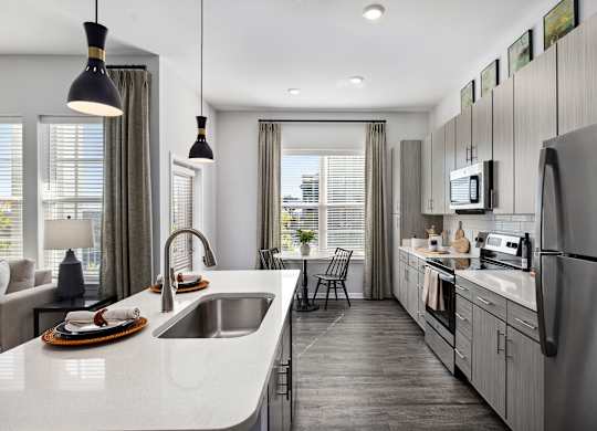 A modern kitchen with a large island and stainless steel appliances.