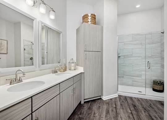 A bathroom with a white sink and a wooden cabinet.