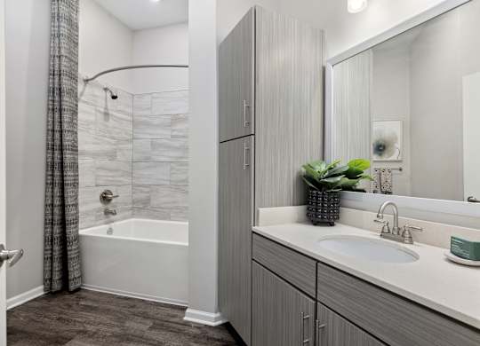 A bathroom with a white tub and sink.