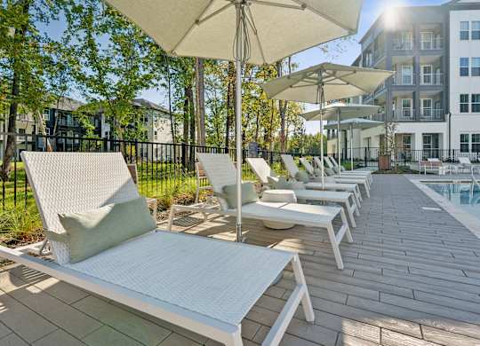 a group of lounge chairs on a deck next to a pool
