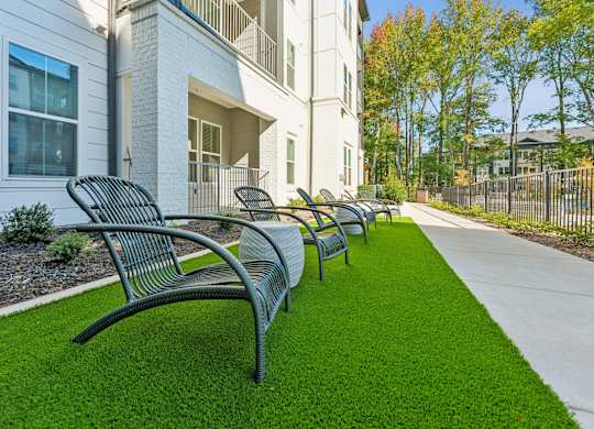 a row of benches on the grass in front of a building