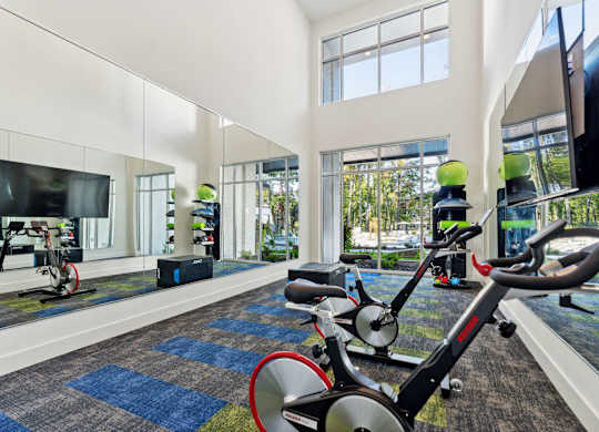 a gym with exercise equipment and large windows