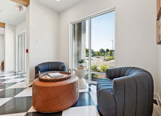 a living room with two chairs and a table and a large window