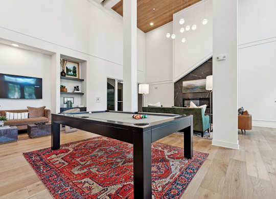 a living room with a pool table in the middle