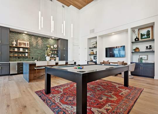 a living room with a pool table in the middle
